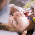 dentes femininos sendo limpos pelo dentista